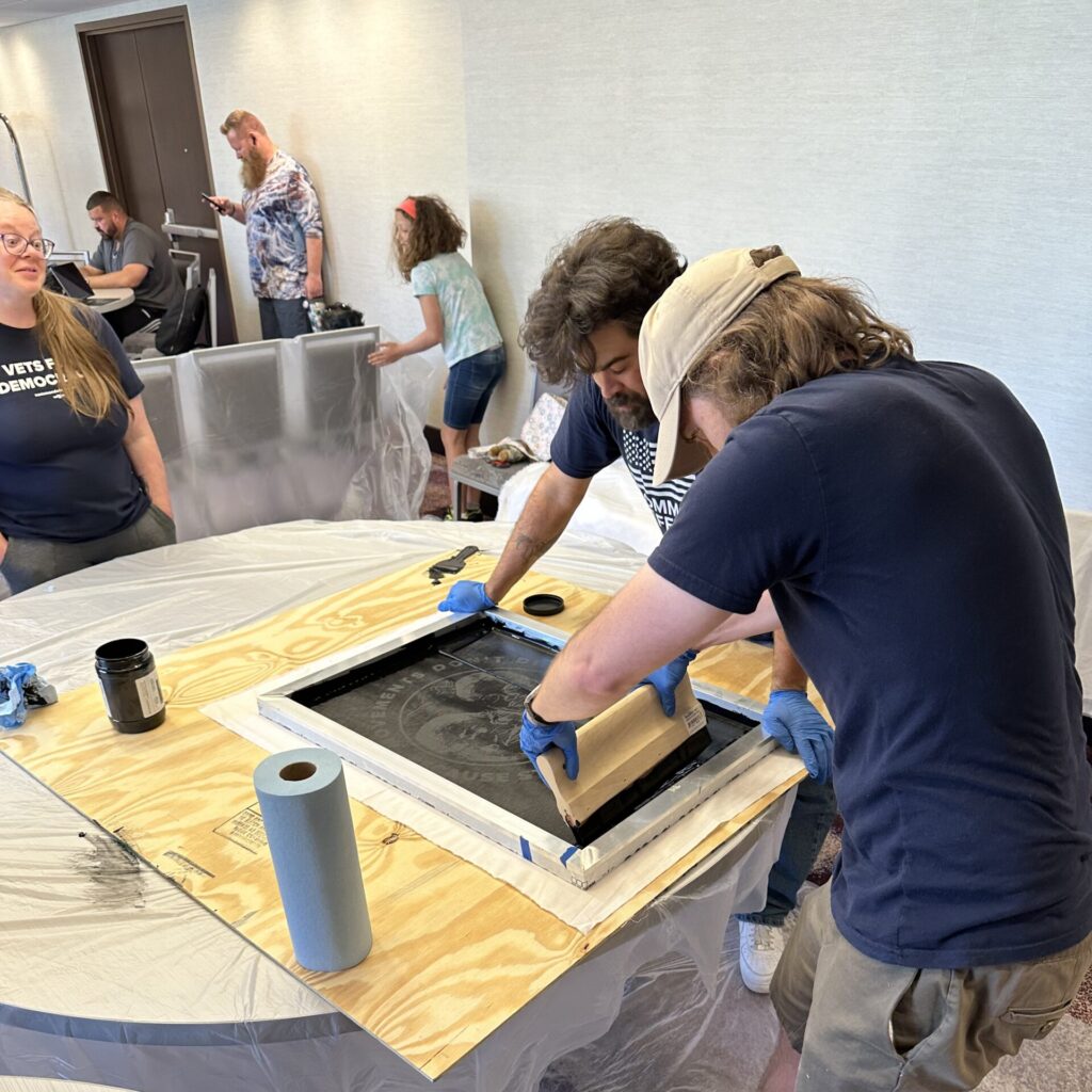 photo of 2 people creating a screen printed sign