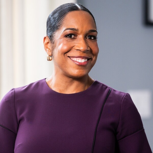 photo of a woman wearing a purple blouse smiling